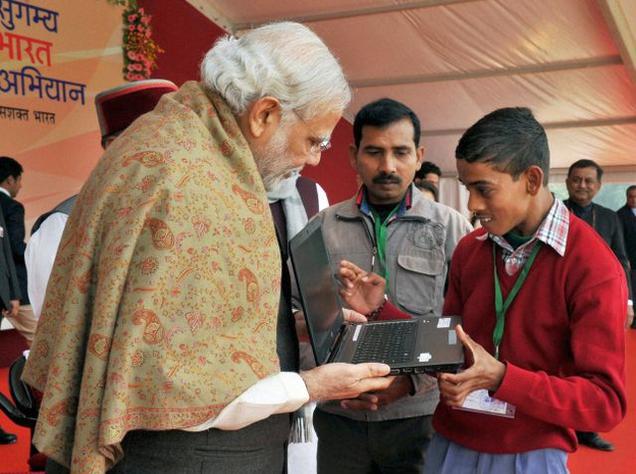 Prime Minister Narendra Modi interacts with a physically challenged child while distributing assistive devices at a function, in Varanasi on Friday.