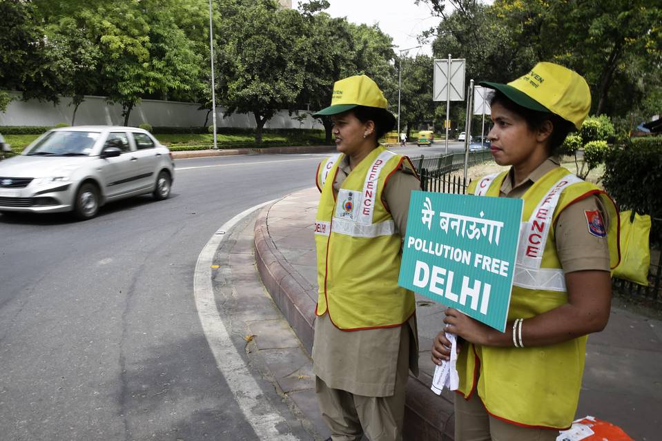 Volunteers remind commuters the reason for restriction placed on vehicle movement in New Delhi, India, Friday, April 15, 2016. 